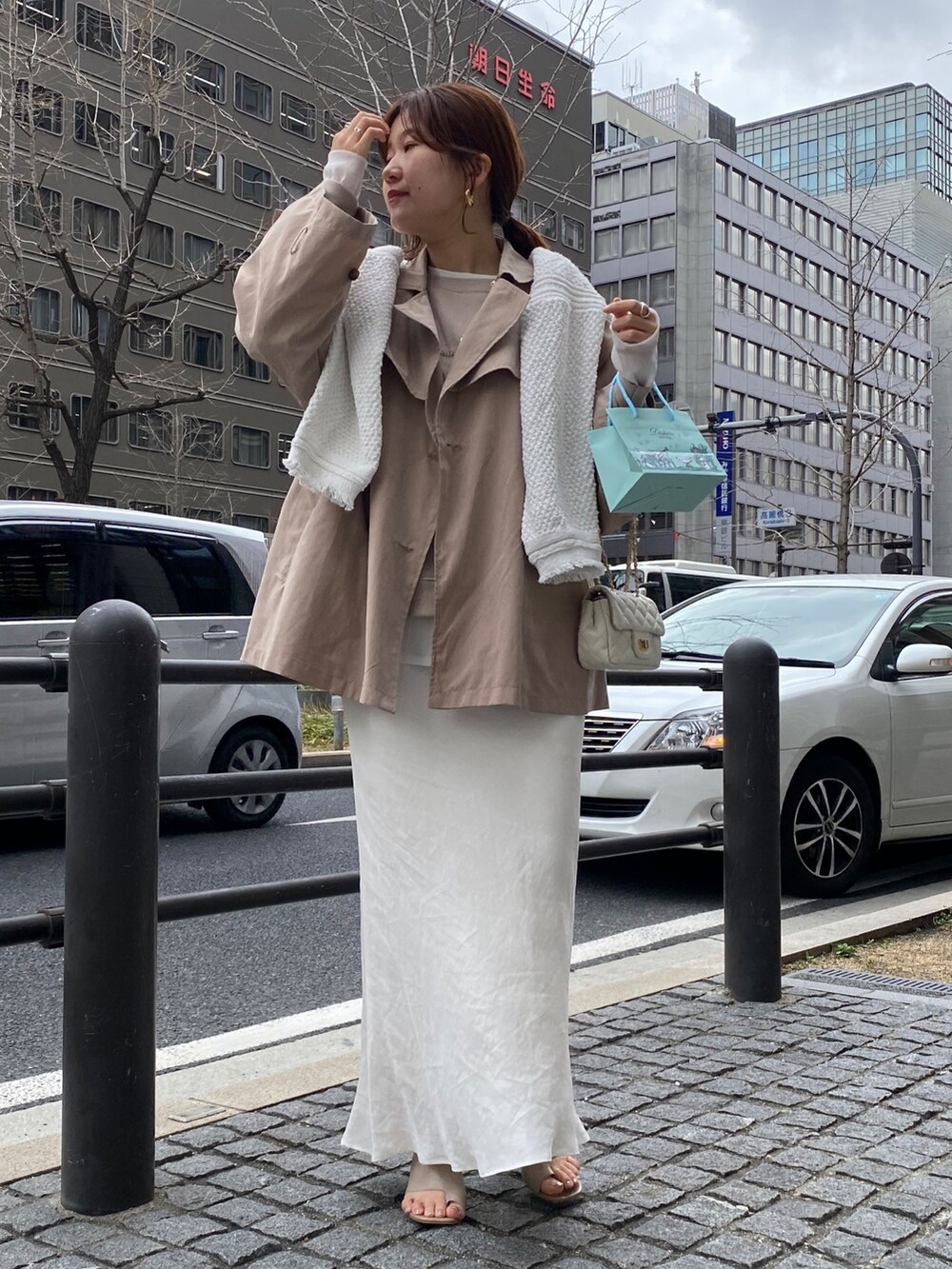 ベージュ系のジャケット/アウター、ホワイト系のスカート、ベージュ系のサンダルを着用したレディースの春コーディネートの6枚目の写真