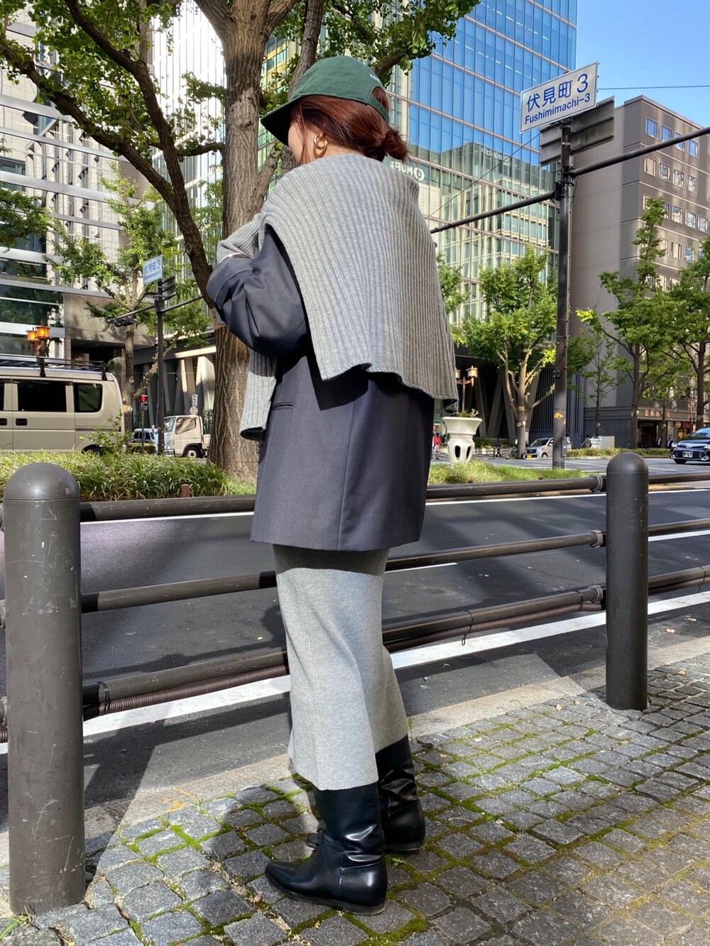 グレー系のテーラードジャケット、ベージュ系のワンピース、ブラック系のブーツを着用したレディースの冬コーディネートの9枚目の写真