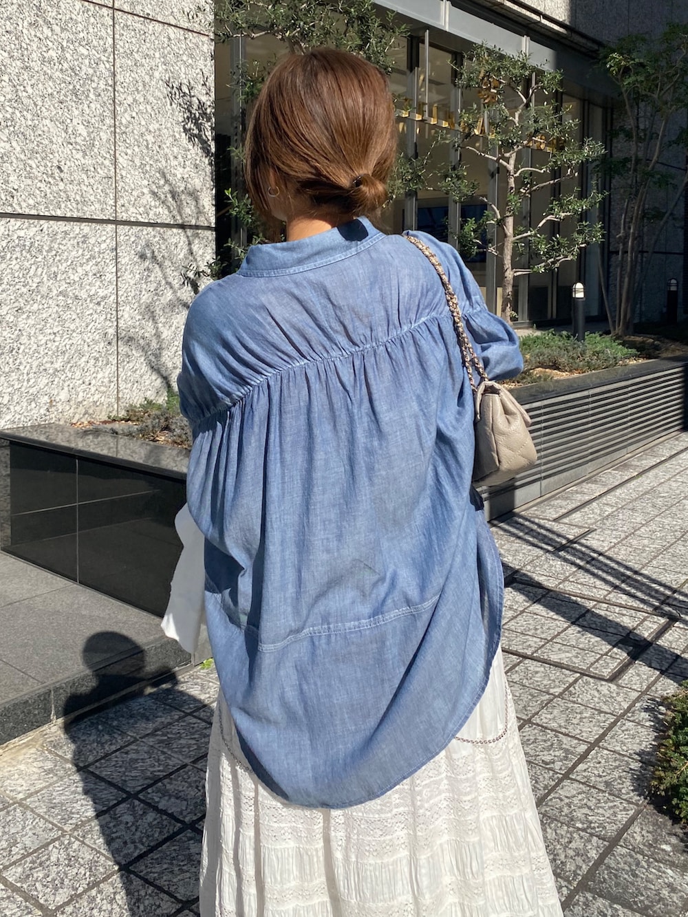 ブルー系のシャツ/ブラウス、ホワイト系のスカート、ホワイト系のTシャツ/カットソーを着用したレディースの春コーディネートの3枚目の写真