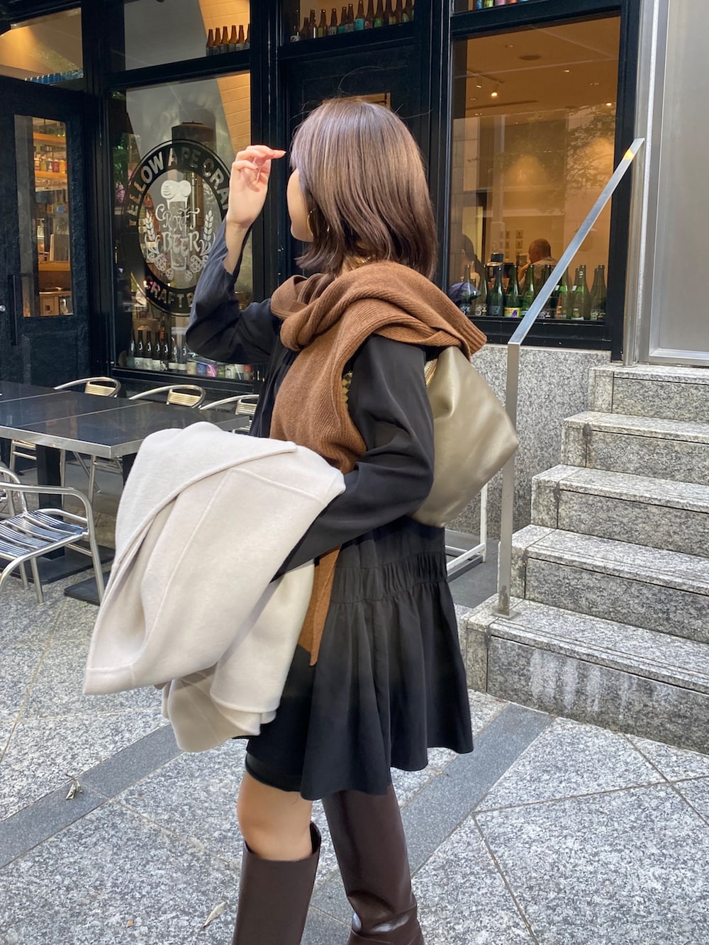 ブラック系のシャツ/ブラウス、ブラウン系のブーツ、ブラウン系のショルダーバッグを着用したレディースの秋コーディネートの3枚目の写真