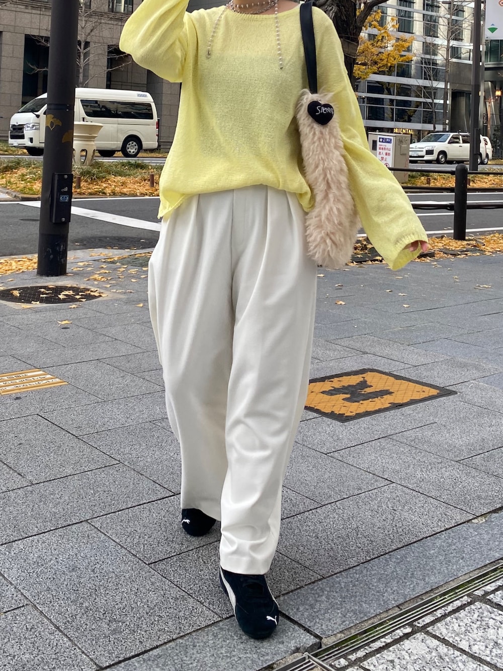 イエロー系のニット/セーター、イエロー系のTシャツ/カットソー、ホワイト系のその他パンツを着用したレディースの冬コーディネートの4枚目の写真