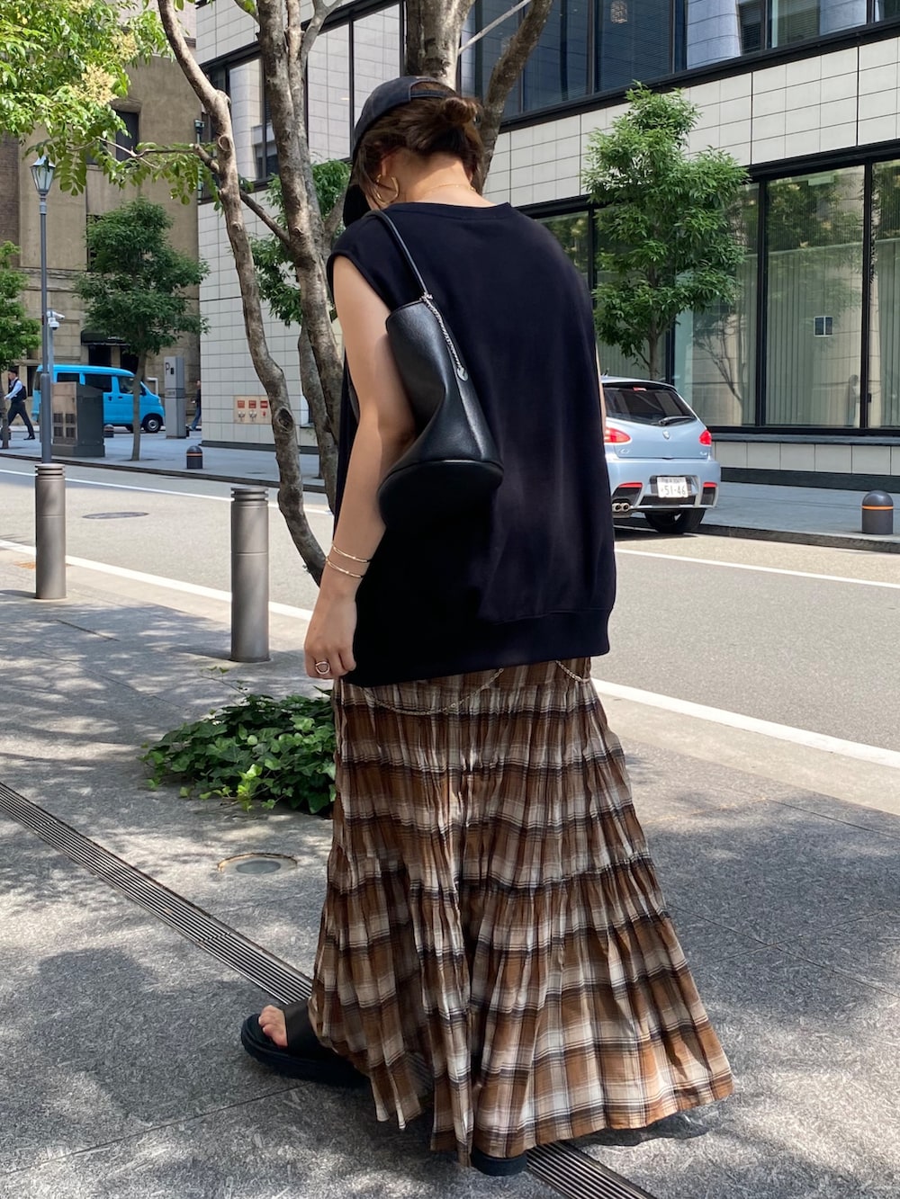 ブラック系のTシャツ/カットソー、ブラウン系のスカート、ブラック系のショルダーバッグを着用したレディースの夏コーディネートの8枚目の写真