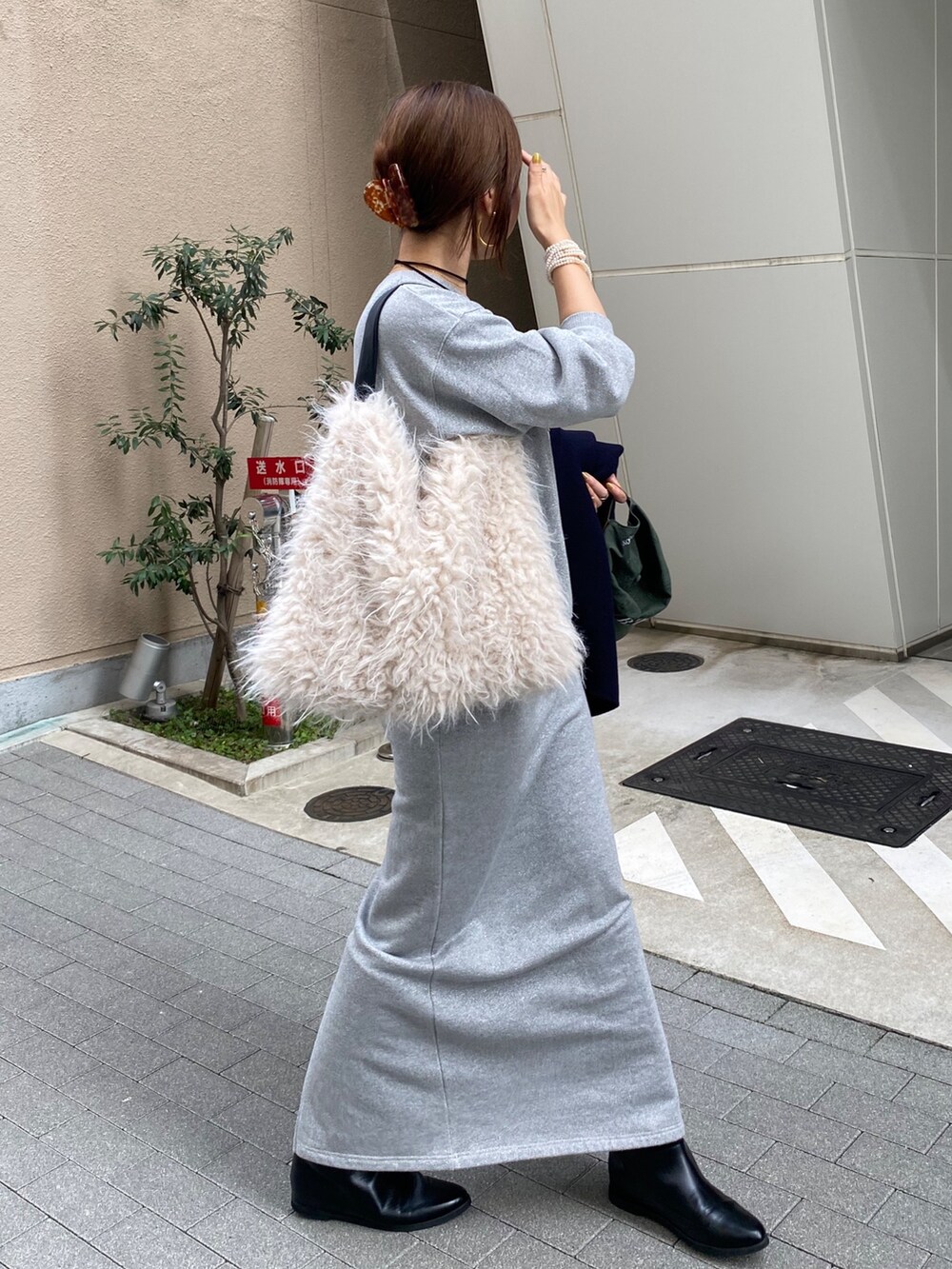 シルバー系のスウェット、シルバー系のスカート、ブラック系のブーツを着用したレディースの秋コーディネートの8枚目の写真