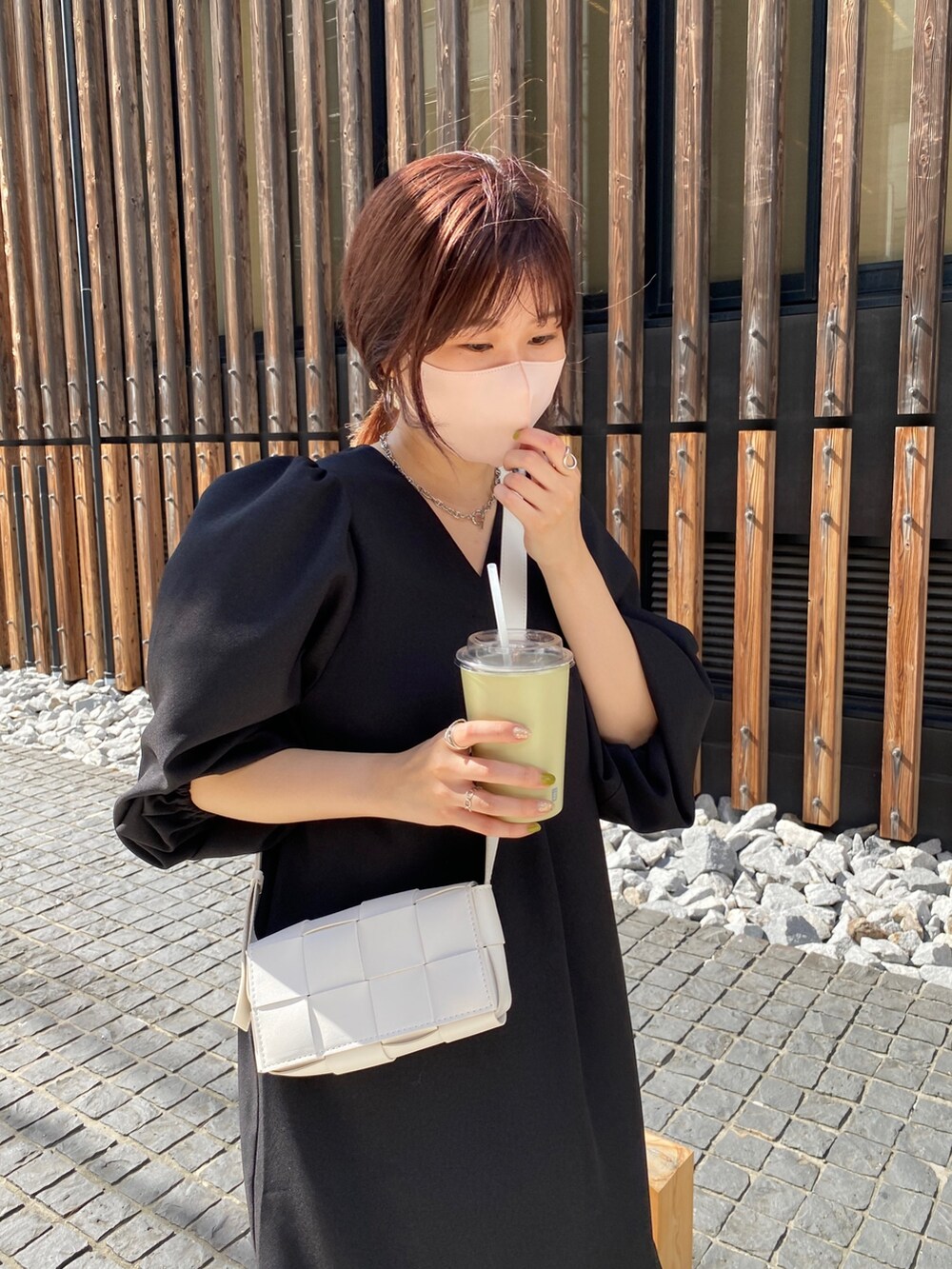 ブラック系のワンピース、ホワイト系のショルダーバッグ、ホワイト系のブーツを着用したレディースの夏コーディネートの5枚目の写真