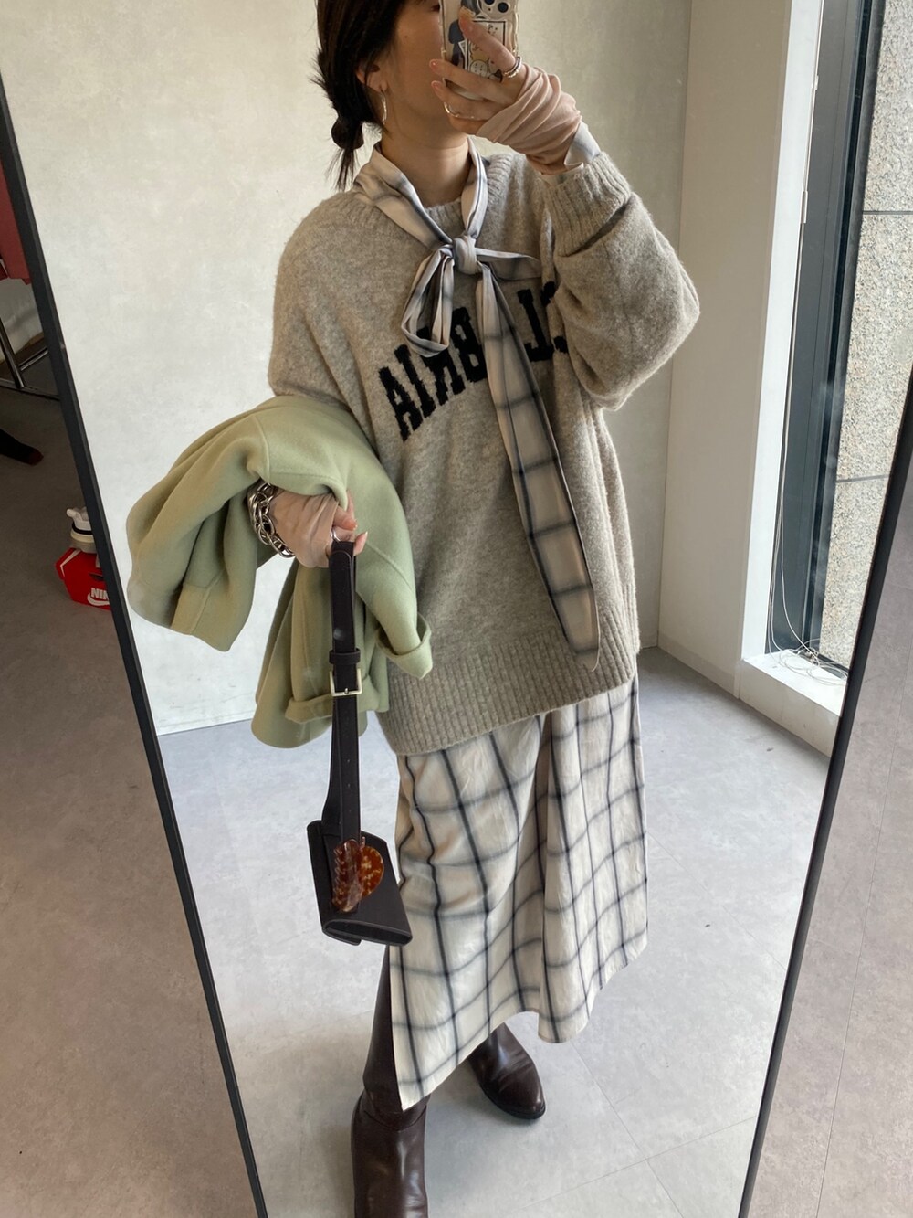 ホワイト系のワンピース、ホワイト系のニット/セーター、ブラウン系のブーツを着用したレディースの冬コーディネートの8枚目の写真