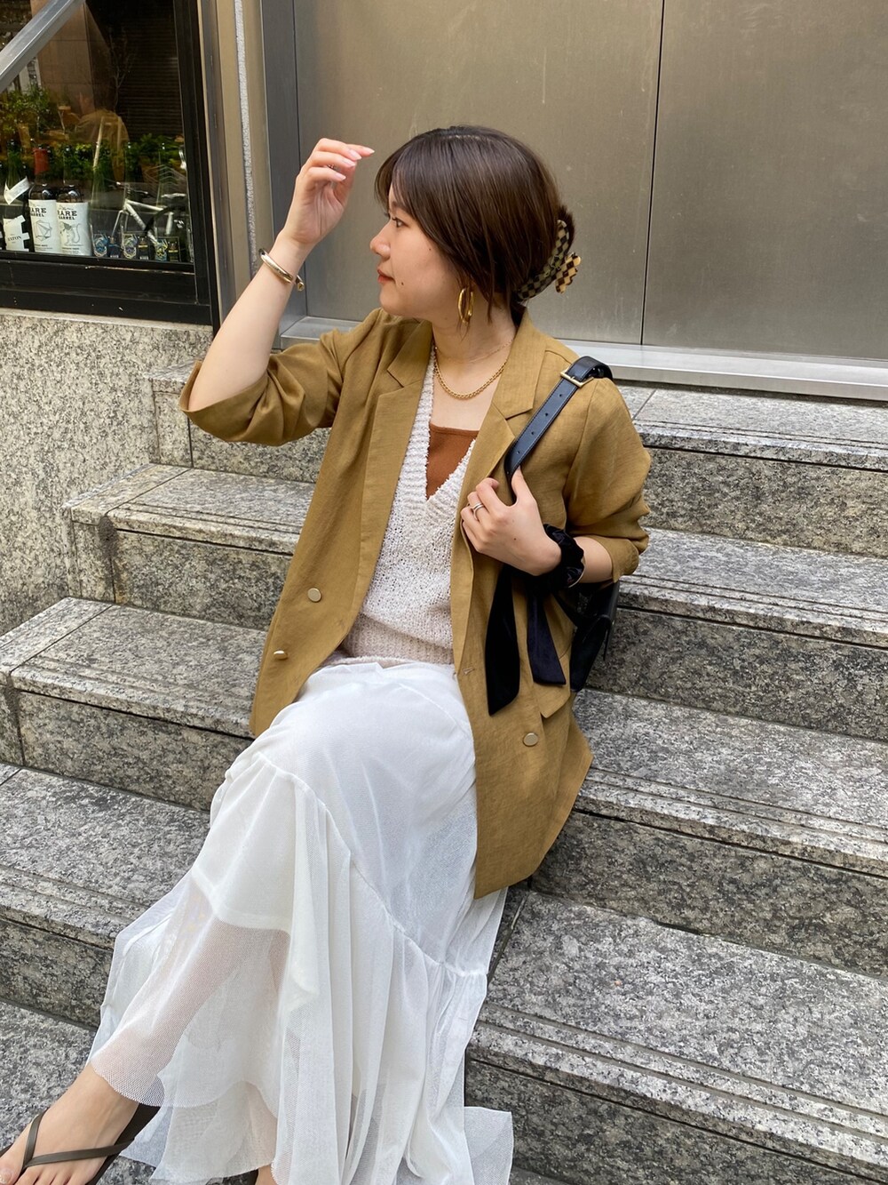 イエロー系のテーラードジャケット、ベージュ系のニット/セーター、ブラウン系のタンクトップを着用したレディースの夏コーディネートの9枚目の写真