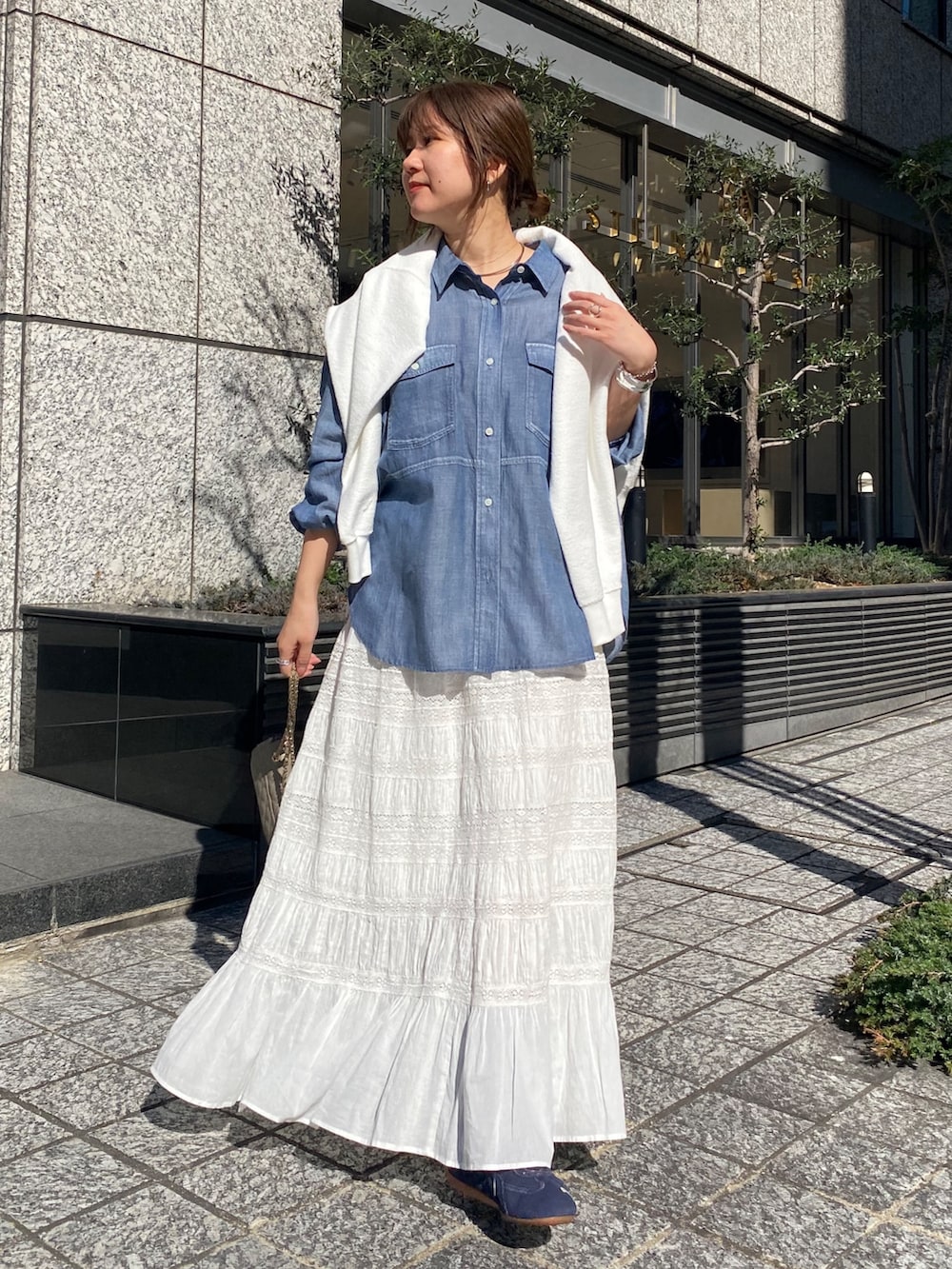 ブルー系のシャツ/ブラウス、ホワイト系のスカート、ホワイト系のTシャツ/カットソーを着用したレディースの春コーディネートの6枚目の写真