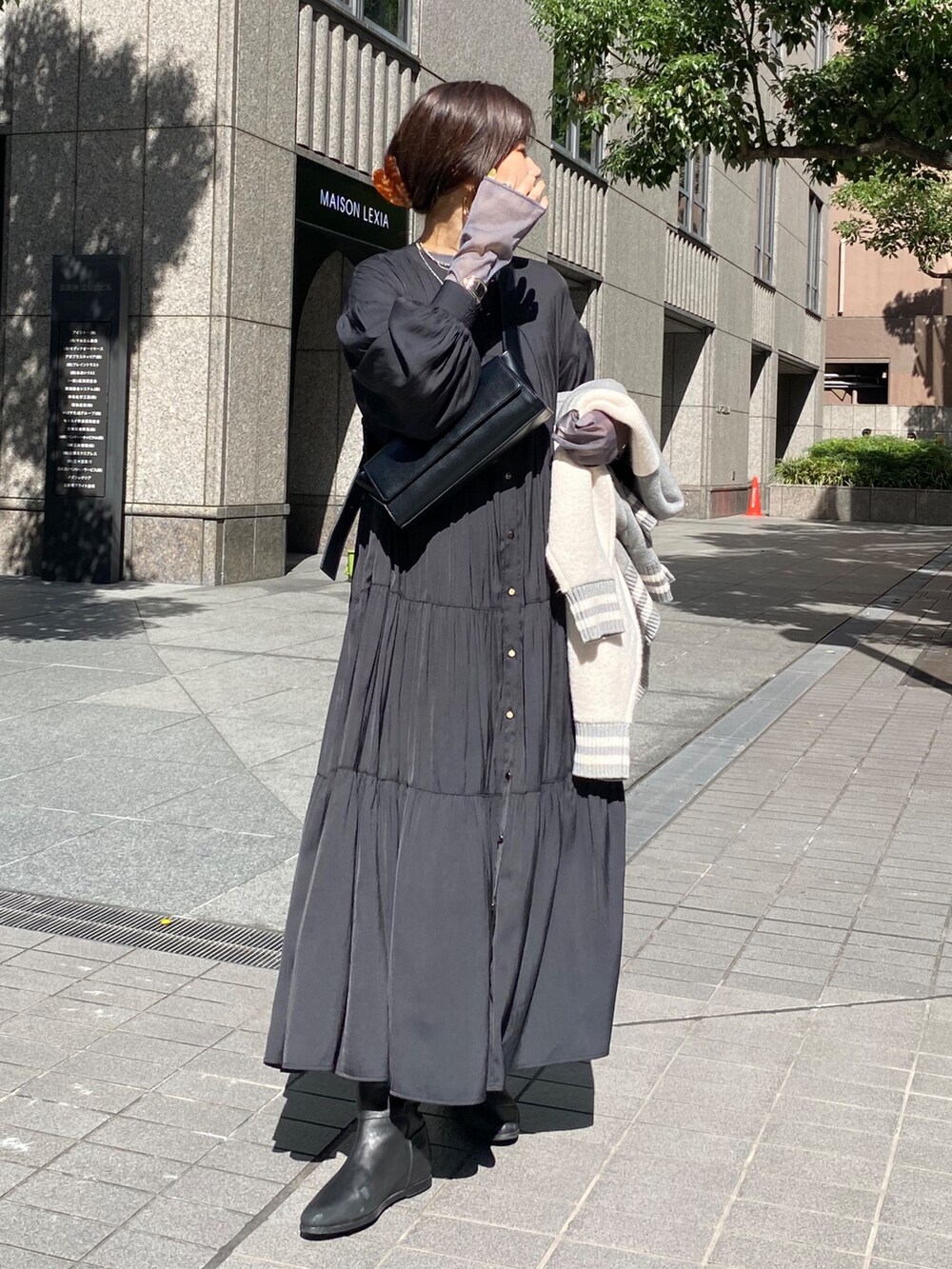 グレー系のその他アウター、ブラック系のワンピース、ブラック系のブーツを着用したレディースの秋コーディネートの9枚目の写真