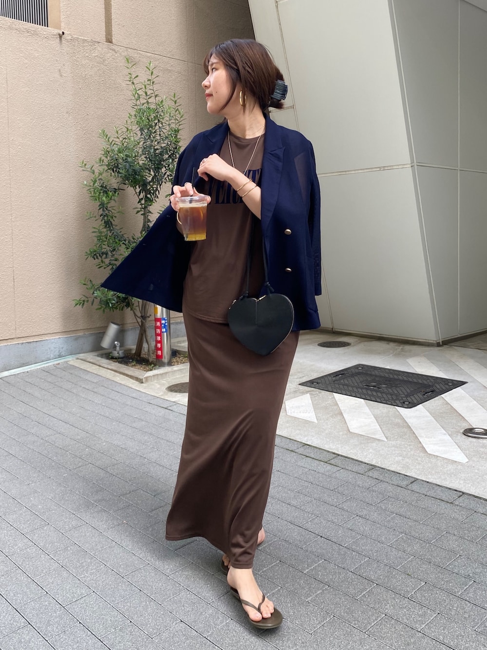 ブラウン系のTシャツ/カットソー、ブラウン系のスカート、ブラック系のショルダーバッグを着用したレディースの夏コーディネートの2枚目の写真