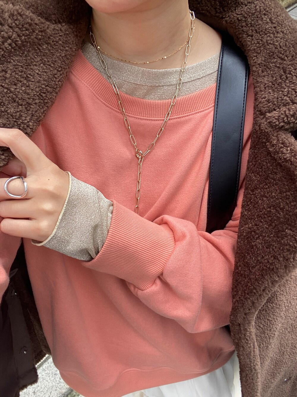 ブラウン系のその他アウター、オレンジ系のスウェット、ホワイト系のスカートを着用したレディースの冬コーディネートの5枚目の写真