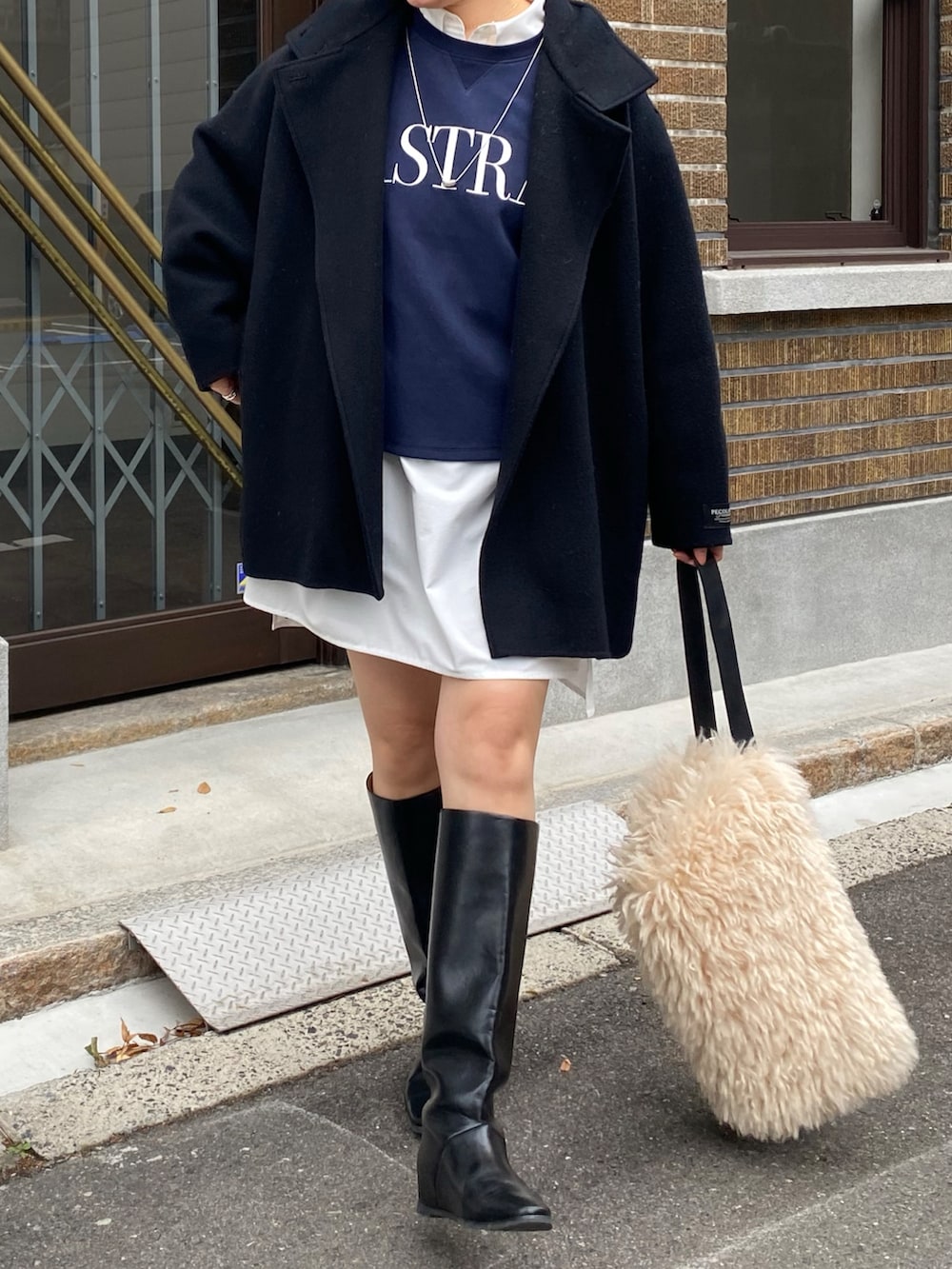 ブラック系のその他アウター、ブルー系のTシャツ/カットソー、ホワイト系のシャツ/ブラウスを着用したレディースの冬コーディネートの8枚目の写真