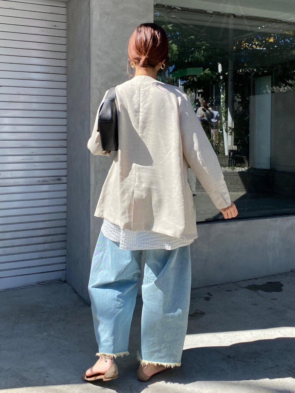 ホワイト系のキャミソール、ブルー系のデニムパンツ、ブラック系のショルダーバッグを着用したレディースの夏コーディネートの9枚目の写真