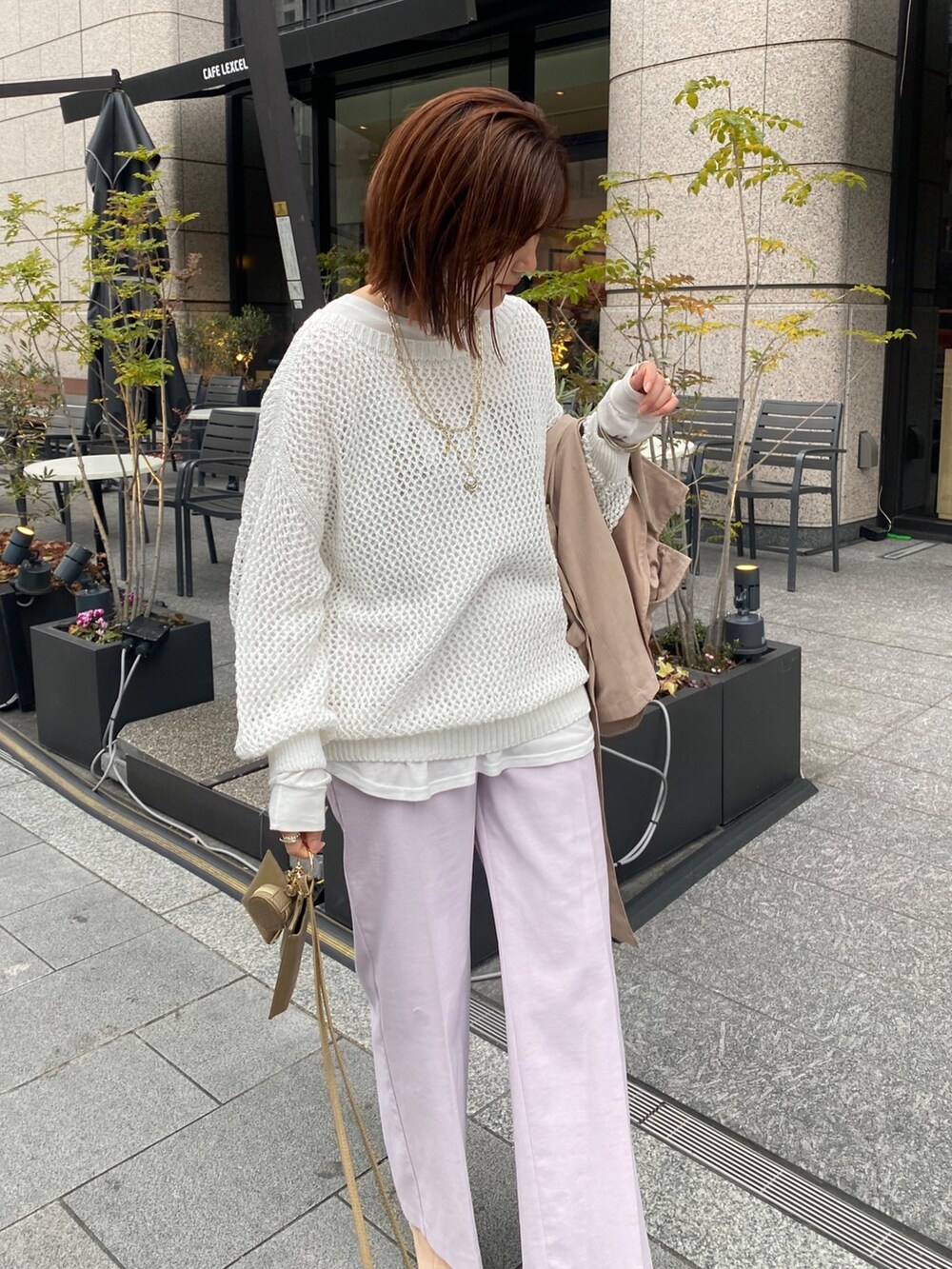 ホワイト系のニット/セーター、ホワイト系のTシャツ/カットソー、ピンク系のスラックスを着用したレディースの冬コーディネートの5枚目の写真