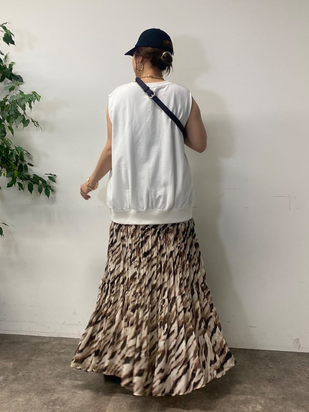 ブラック系のショルダーバッグ、ホワイト系のTシャツ/カットソー、ベージュ系のスカートを着用したレディースの夏コーディネートの2枚目の写真