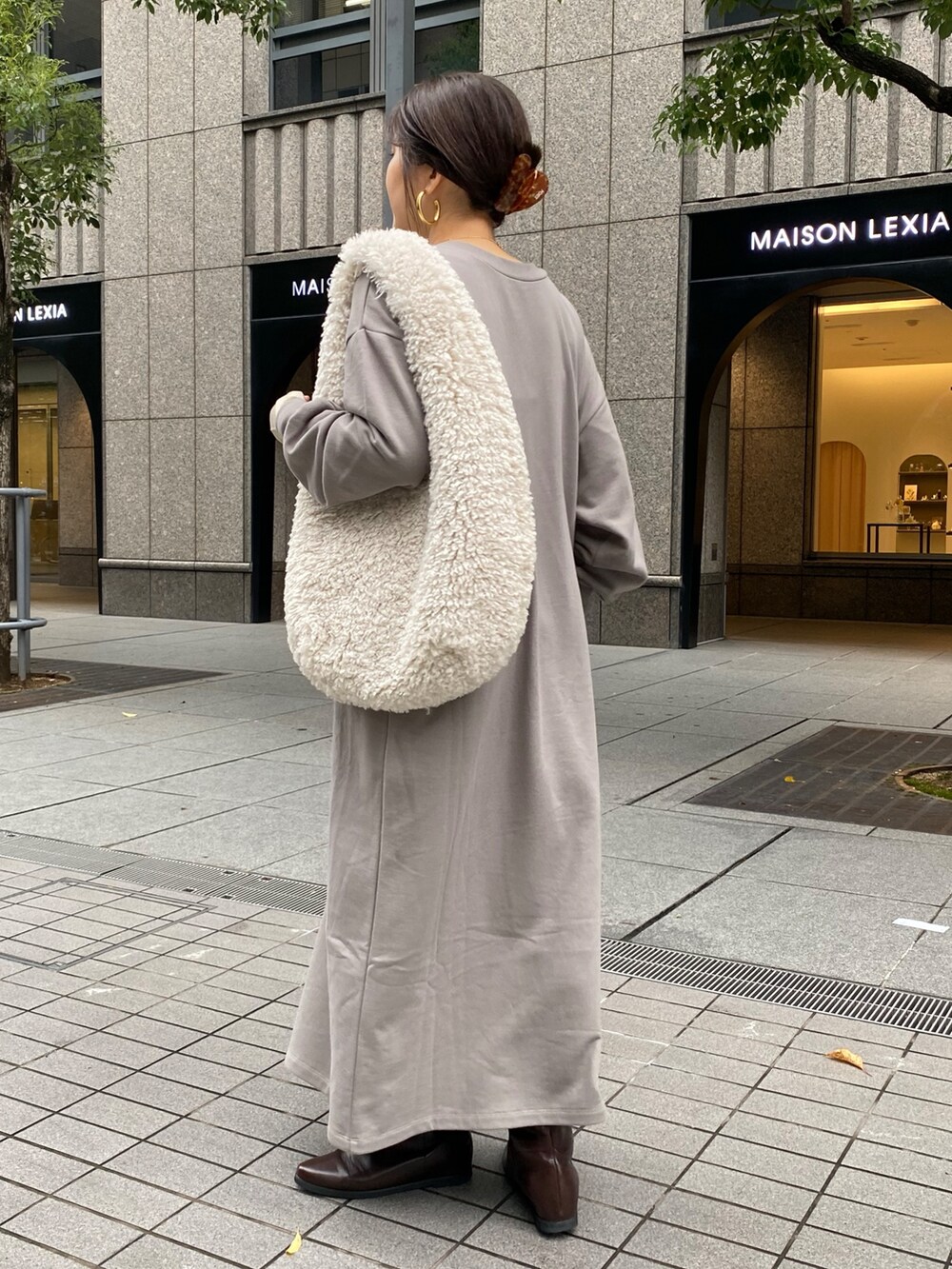 グレー系のワンピース、ブラウン系のブーツ、ゴールド系のTシャツ/カットソーを着用したレディースの秋コーディネートの6枚目の写真