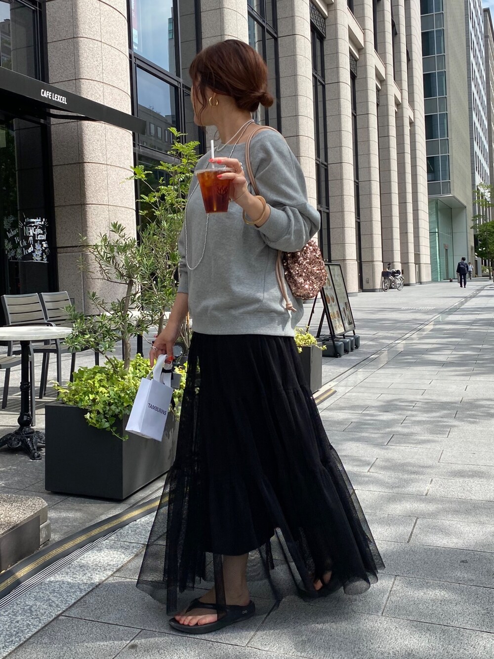 グレー系のスウェット、ブラック系のスカート、ピンク系のハンドバッグを着用したレディースの秋コーディネートの5枚目の写真