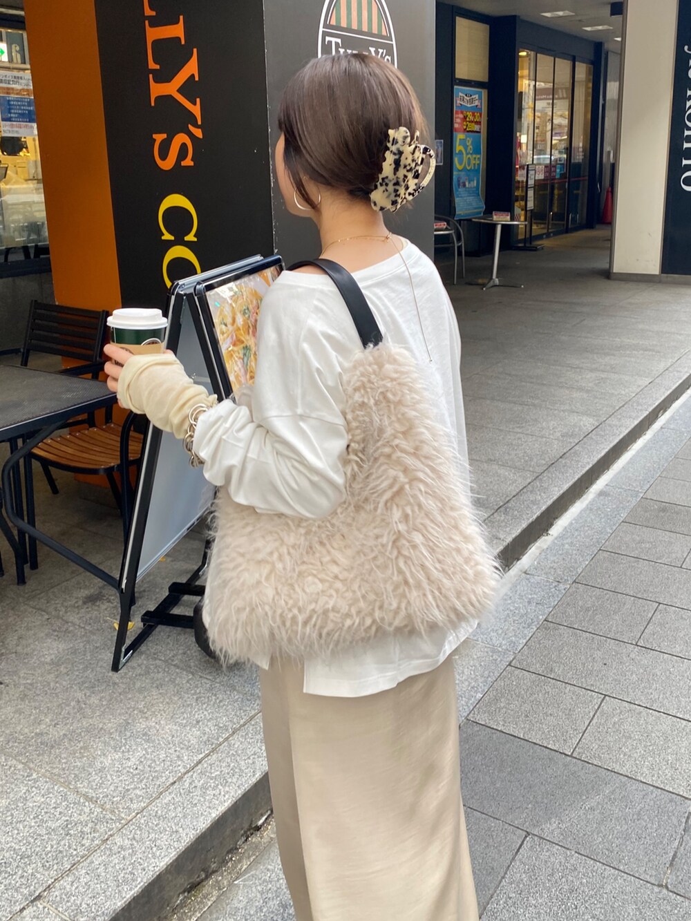 ホワイト系のTシャツ/カットソー、ベージュ系のスカート、イエロー系のTシャツ/カットソーを着用したレディースの冬コーディネートの6枚目の写真