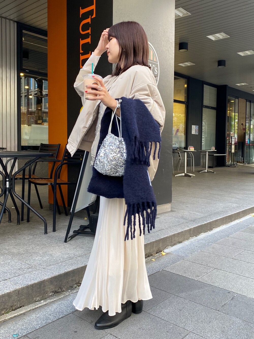 ベージュ系のMA-1、ベージュ系のベスト、ホワイト系のスカートを着用したレディースの秋コーディネートの8枚目の写真