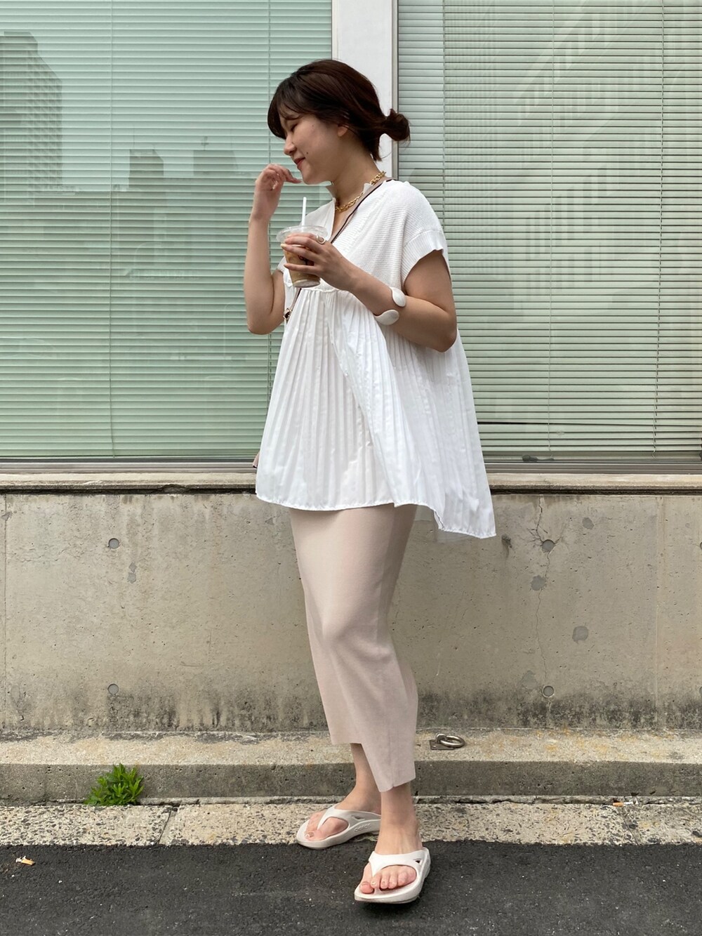 ホワイト系のニット/セーター、ベージュ系のスカート、ホワイト系のサンダルを着用したレディースの夏コーディネートの3枚目の写真