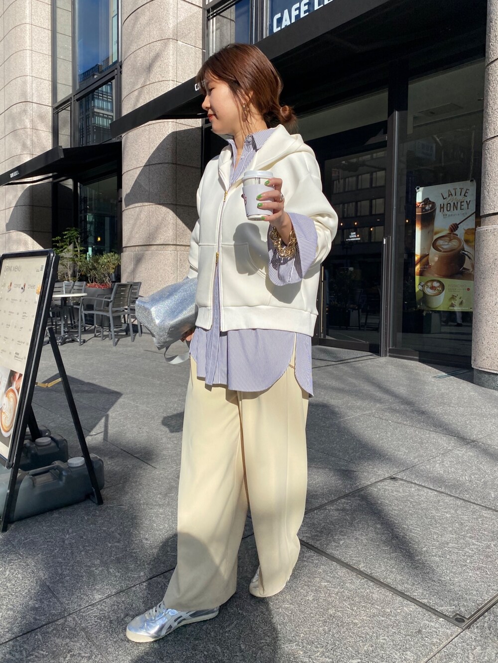 ホワイト系のパーカー、ブラック系のシャツ/ブラウス、イエロー系のスラックスを着用したレディースの冬コーディネートの6枚目の写真