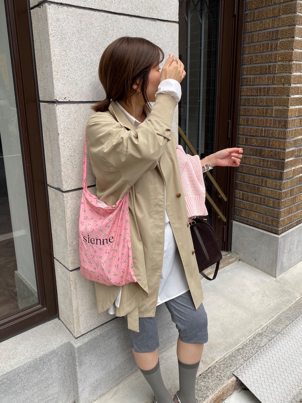 ピンク系のニット/セーター、ホワイト系のシャツ/ブラウス、グレー系のその他パンツを着用したレディースの春コーディネートの2枚目の写真