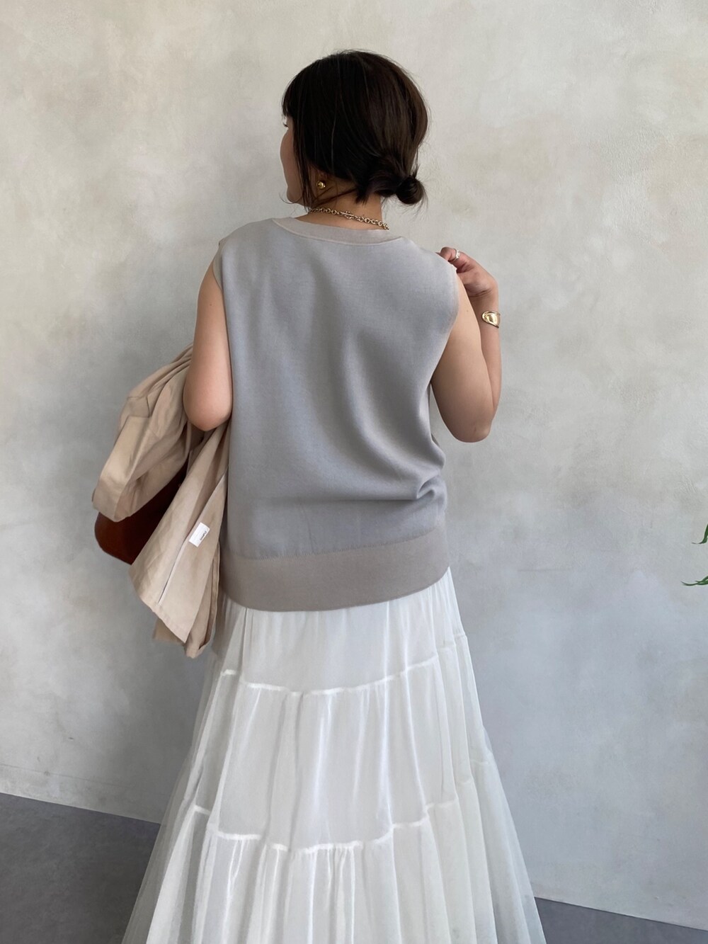 ベージュ系のテーラードジャケット、ホワイト系のスカート、ブラウン系のショルダーバッグを着用したレディースの夏コーディネートの3枚目の写真