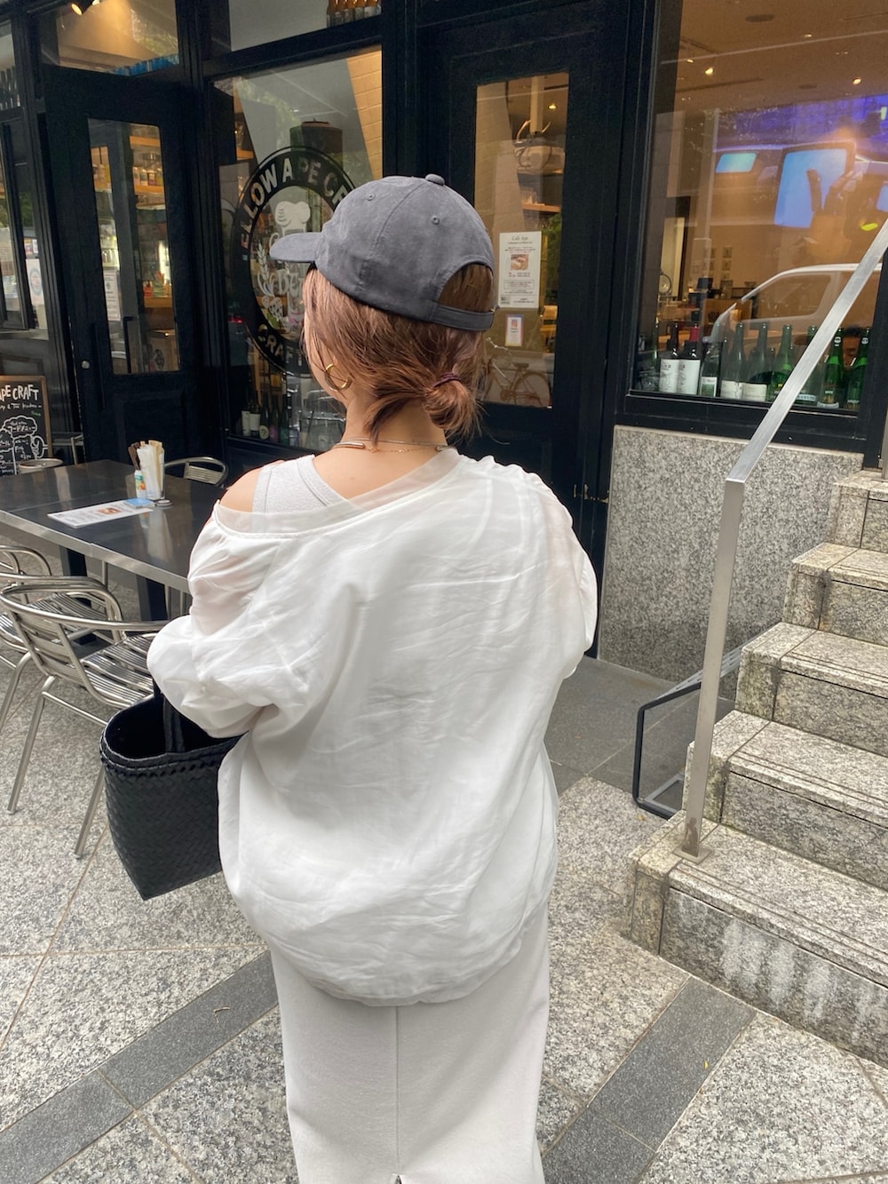 ベージュ系のワンピース、ホワイト系のブルゾン、ブラック系のかごバッグを着用したレディースの春コーディネートの4枚目の写真