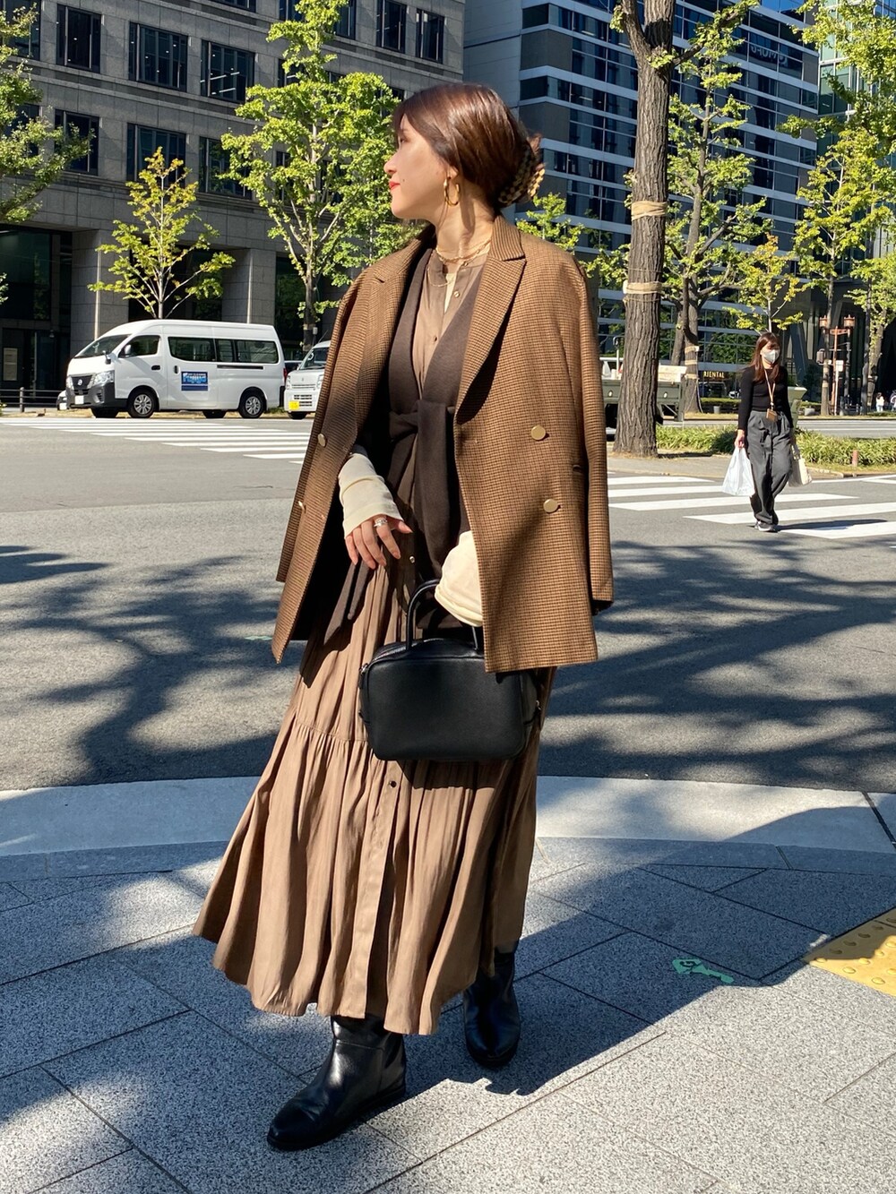 ブラウン系のベスト、ブラウン系のテーラードジャケット、ブラウン系のワンピースを着用したレディースの冬コーディネートの7枚目の写真