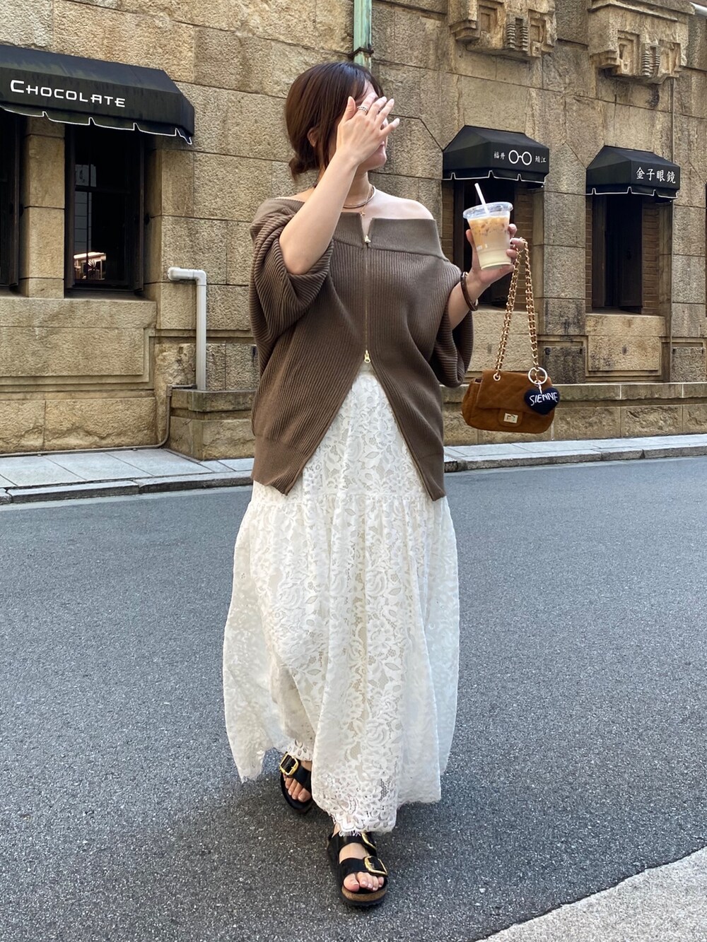 ブラウン系のニット/セーター、イエロー系のショルダーバッグ、ホワイト系のスカートを着用したレディースの秋コーディネートの2枚目の写真