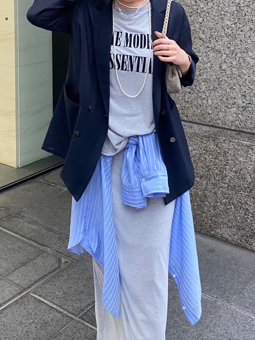 ブルー系のテーラードジャケット、グレー系のTシャツ/カットソー、グレー系のスカートを着用したレディースの春コーディネートの3枚目の写真