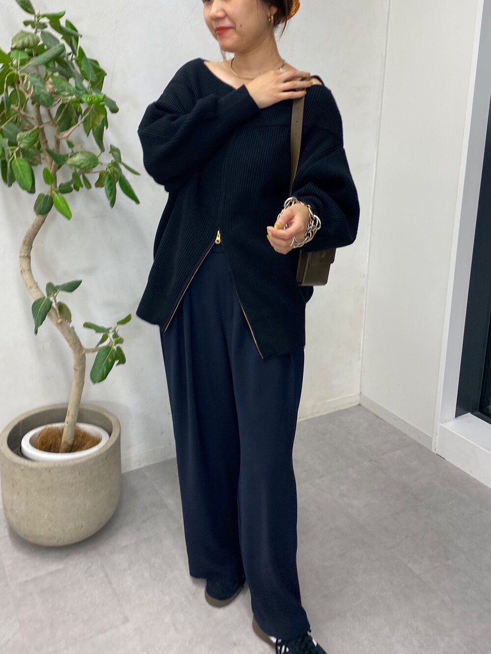 ブラック系のニット/セーター、ブルー系のスラックス、ゴールド系のサスペンダーを着用したレディースの秋コーディネートの7枚目の写真