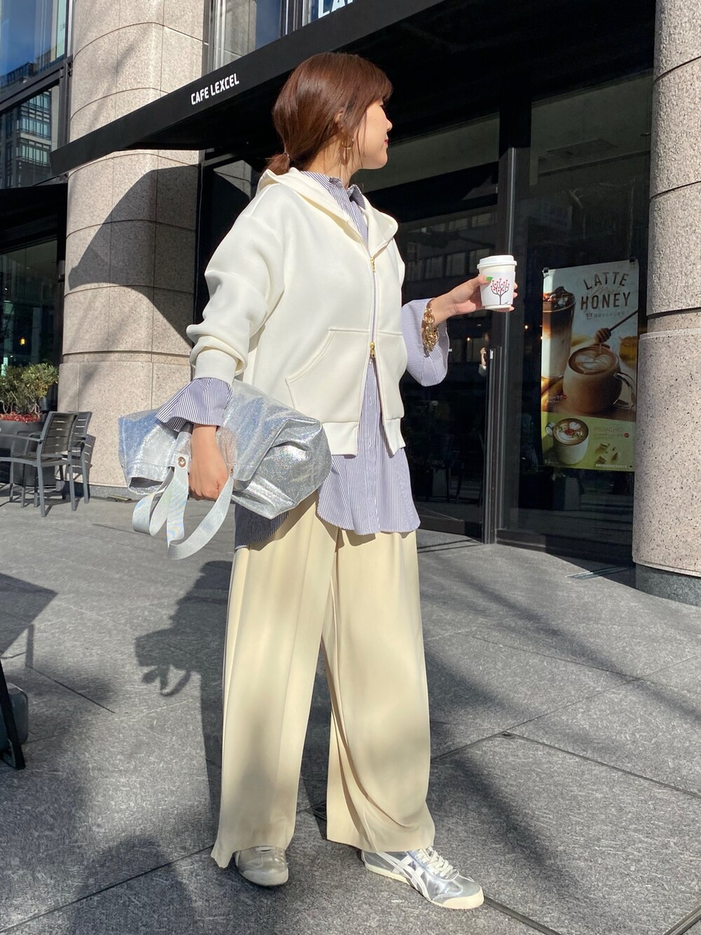 ホワイト系のパーカー、ブラック系のシャツ/ブラウス、イエロー系のスラックスを着用したレディースの冬コーディネートの8枚目の写真