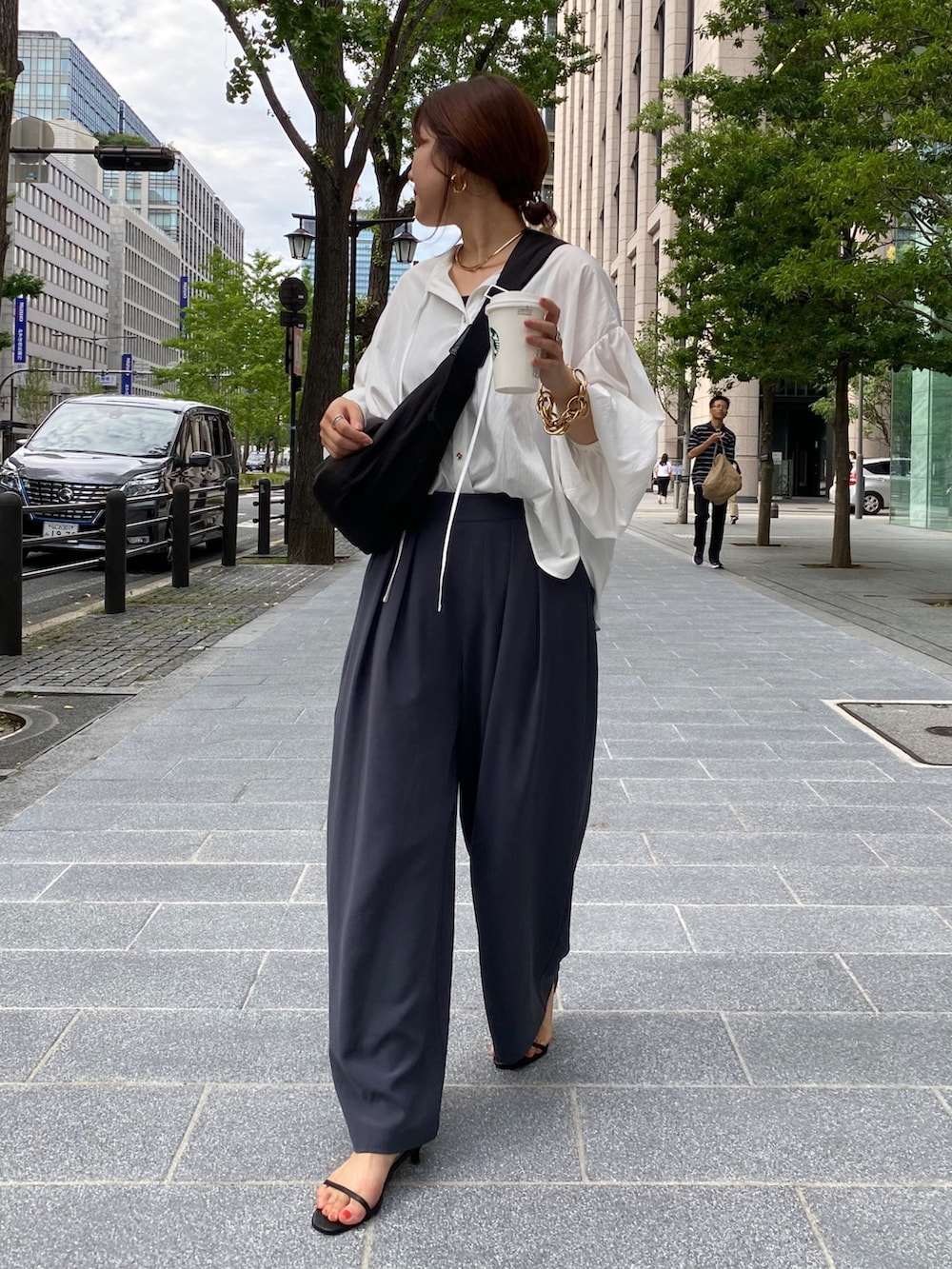 ホワイト系のシャツ/ブラウス、グレー系のスラックス、シルバー系のサンダルを着用したレディースの夏コーディネートの4枚目の写真