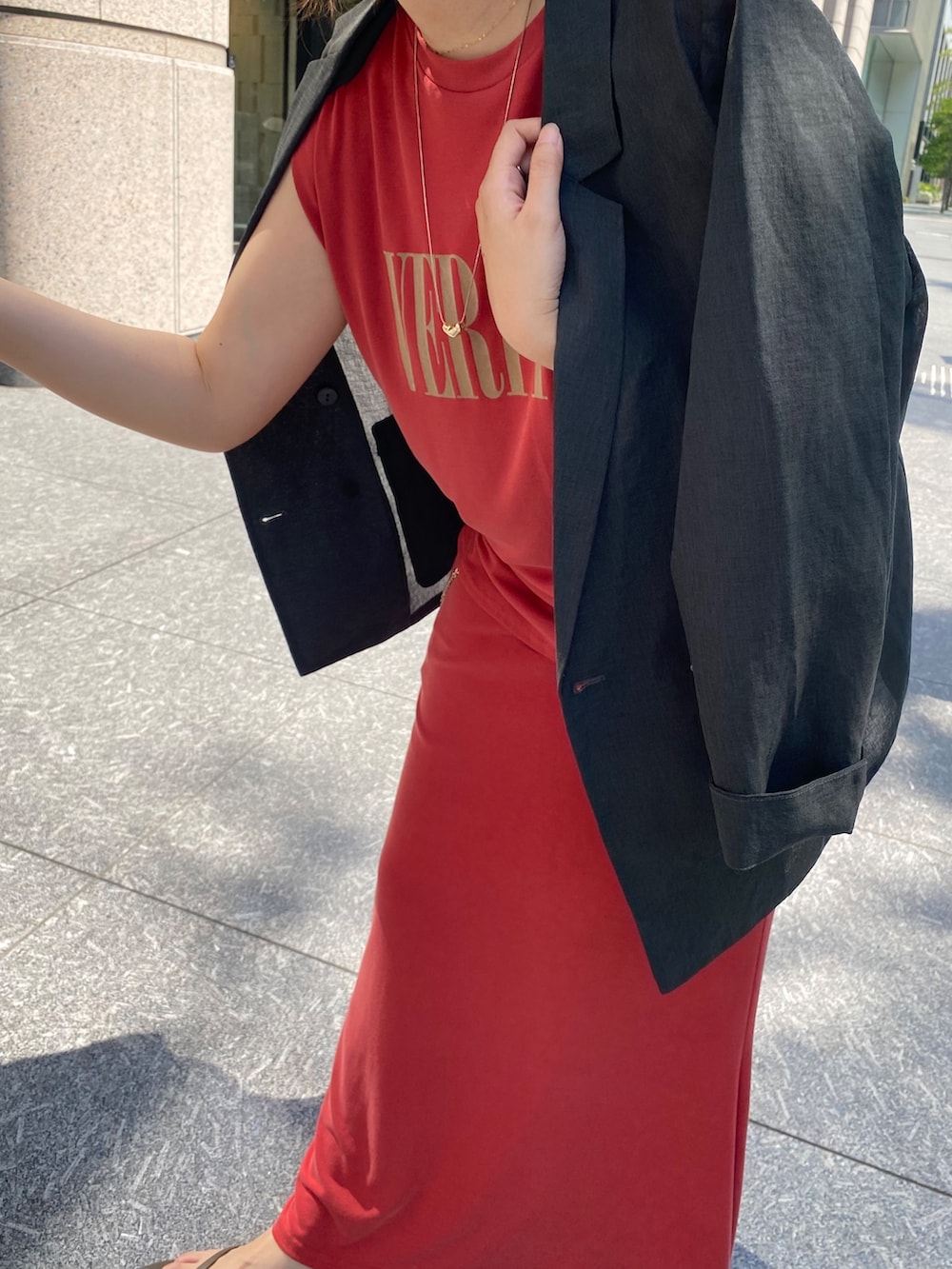 グレー系のテーラードジャケット、レッド系のTシャツ/カットソー、ブラック系のショルダーバッグを着用したレディースの春コーディネートの9枚目の写真