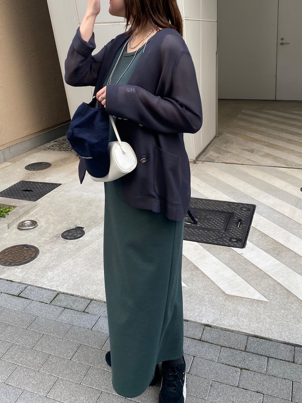 グレー系のテーラードジャケット、グリーン系のワンピースを着用したレディースの春コーディネートの7枚目の写真