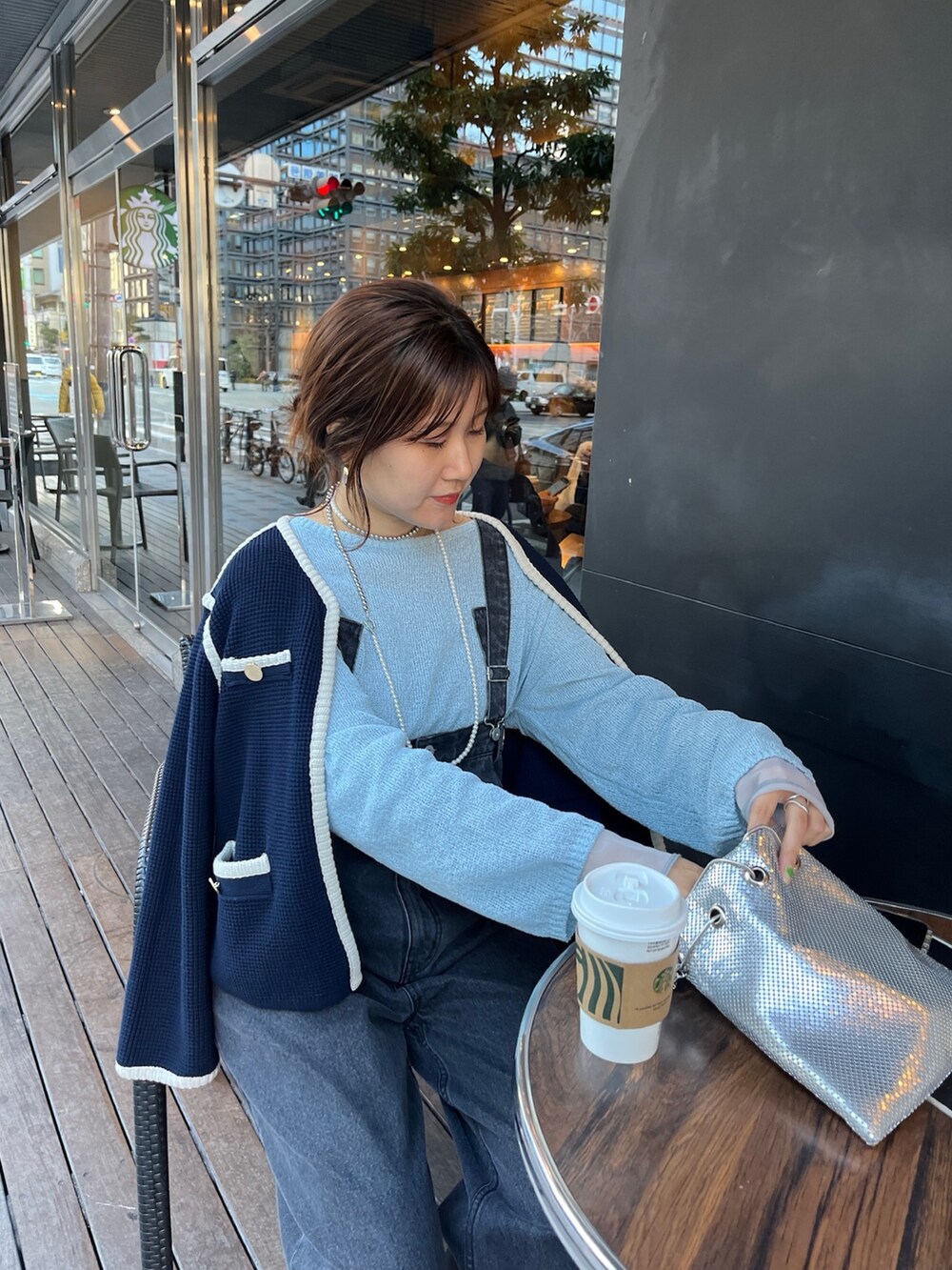 ブルー系のノーカラージャケット、ブラック系のサロペット/オーバーオール、ゴールド系のショルダーバッグを着用したレディースの冬コーディネートの4枚目の写真