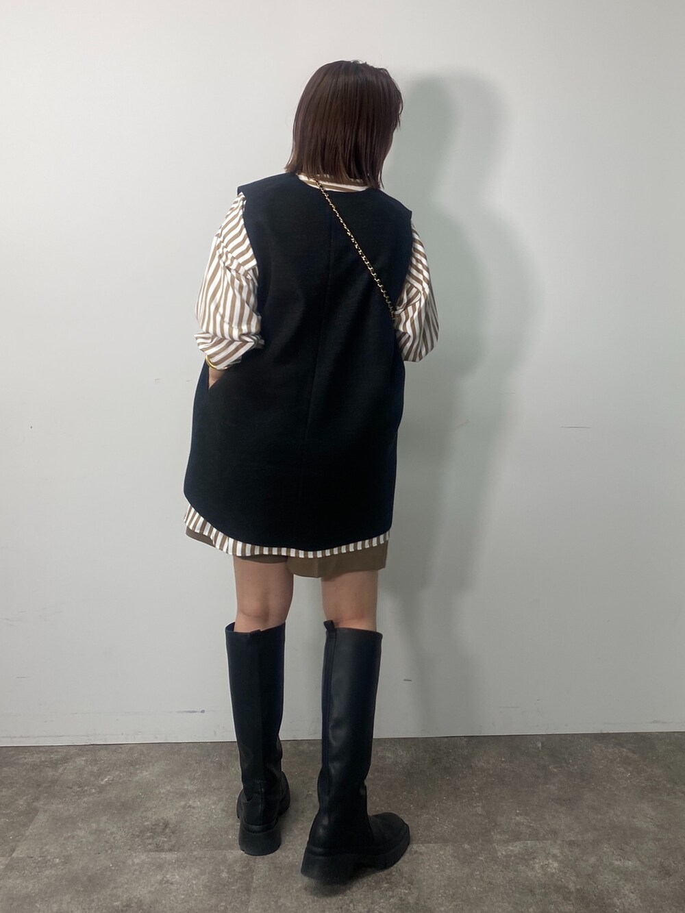 グレー系のベスト、ベージュ系のシャツ/ブラウス、イエロー系のその他パンツを着用したレディースの秋コーディネートの3枚目の写真