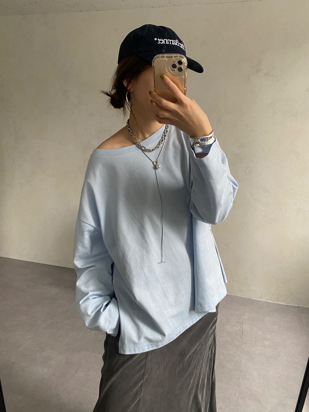 ブルー系のTシャツ/カットソー、ブラック系のスカート、ブラック系のショルダーバッグを着用したレディースの春コーディネートの2枚目の写真