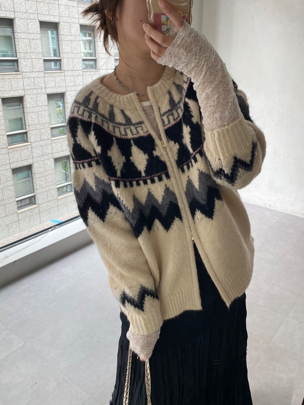 ホワイト系のカーディガン/ボレロ、ホワイト系のTシャツ/カットソー、ブラック系のスカートを着用したレディースの冬コーディネートの4枚目の写真