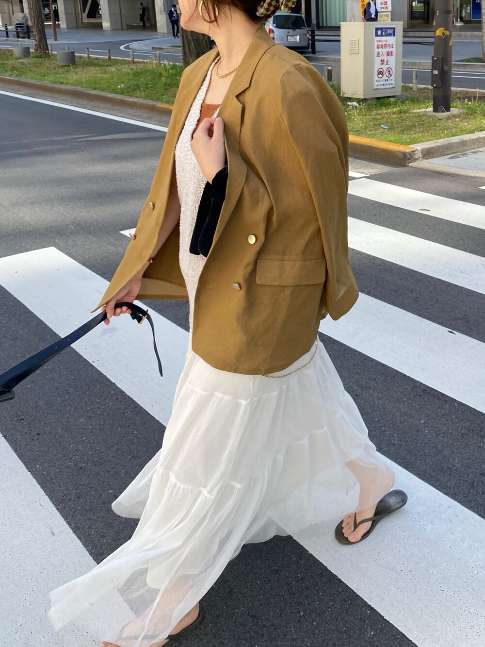 イエロー系のテーラードジャケット、ベージュ系のニット/セーター、ブラウン系のタンクトップを着用したレディースの夏コーディネートの7枚目の写真