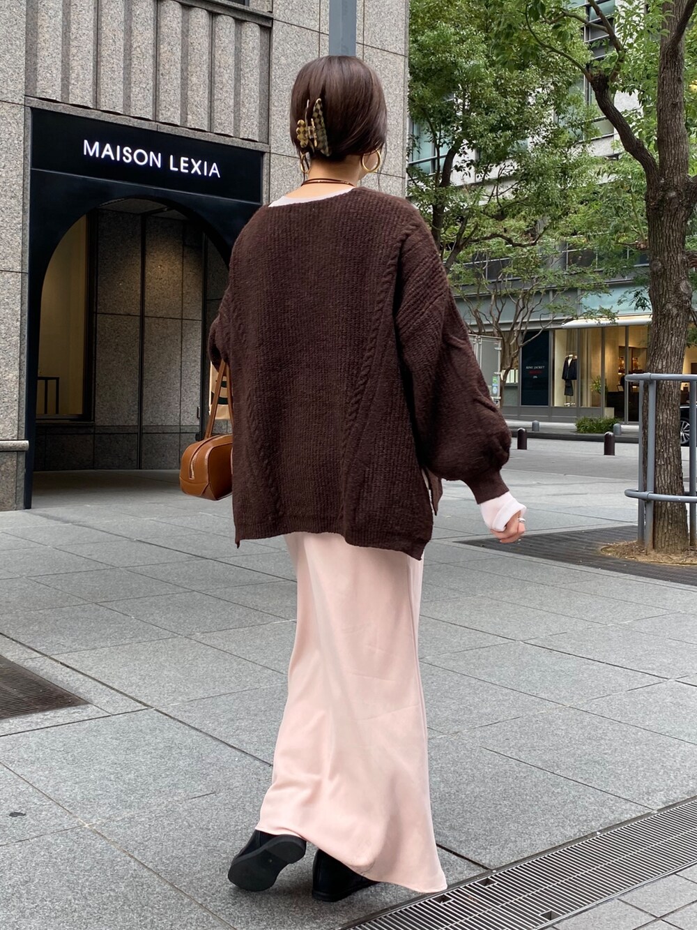 ブラウン系のニット/セーター、ピンク系のスカート、ブラック系のブーツを着用したレディースの冬コーディネートの7枚目の写真