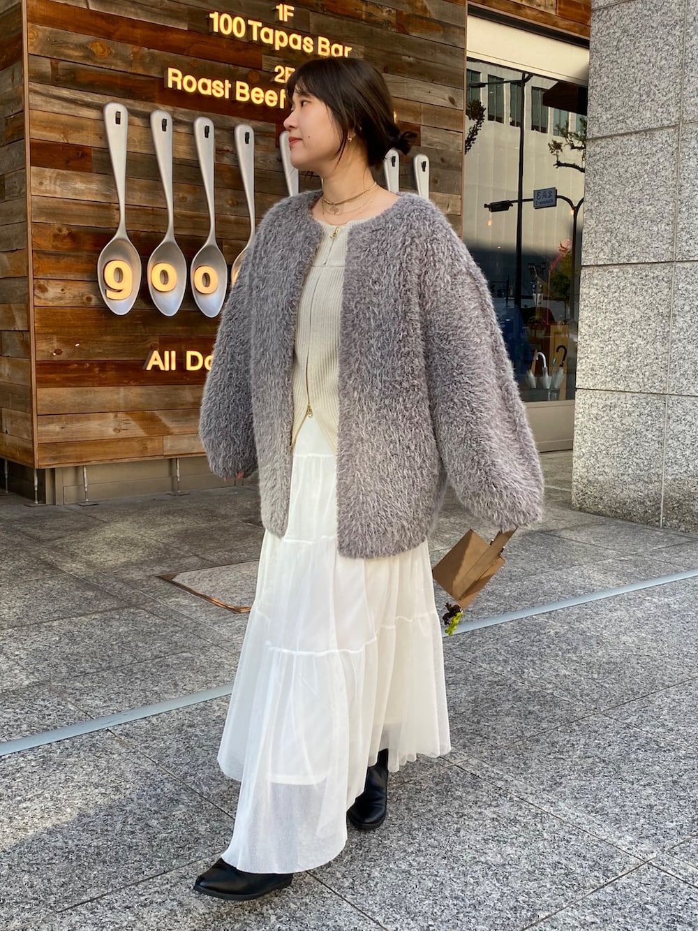 ベージュ系のニット/セーター、ホワイト系のスカート、グレー系のその他アウターを着用したレディースの冬コーディネートの3枚目の写真