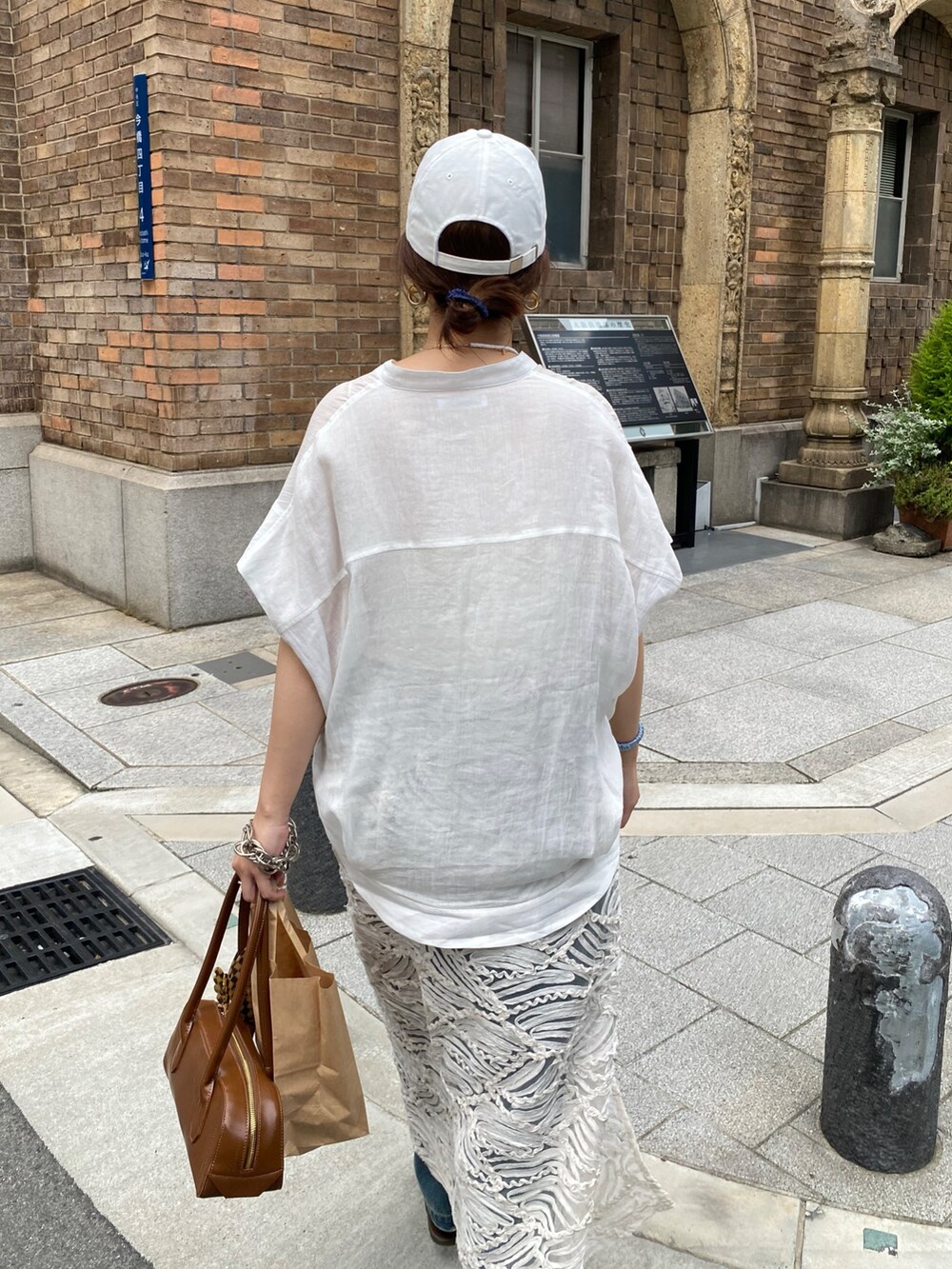 ピンク系のシャツ/ブラウス、ブルー系のデニムパンツ、ホワイト系のネックレスを着用したレディースの夏コーディネートの4枚目の写真