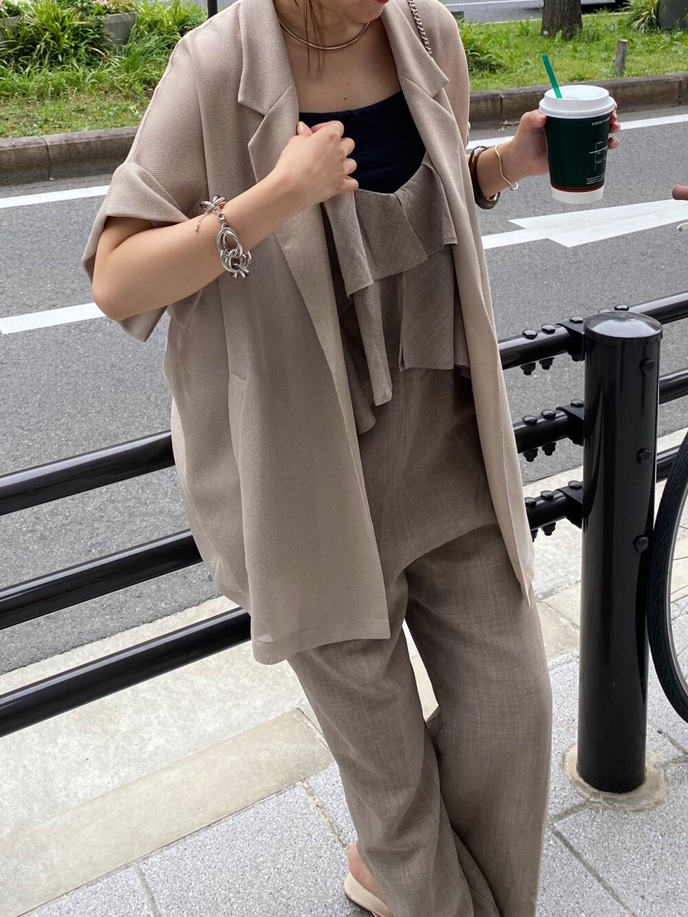 ベージュ系のテーラードジャケット、ベージュ系のつなぎ/オールインワン、ブラウン系のキャップを着用したレディースの夏コーディネートの5枚目の写真