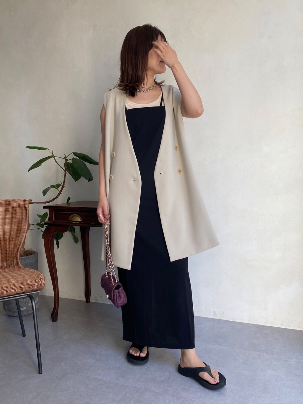 ベージュ系のベスト、ブラック系のワンピース、ブラック系のサンダルを着用したレディースの夏コーディネートの2枚目の写真