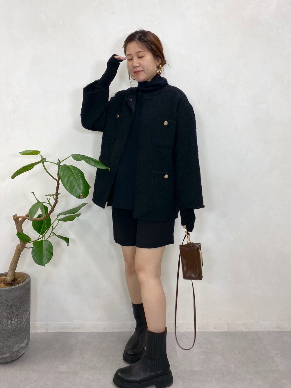 ブラック系のノーカラージャケット、ブラック系のニット/セーター、ブラック系のブーツを着用したレディースの秋コーディネートの3枚目の写真