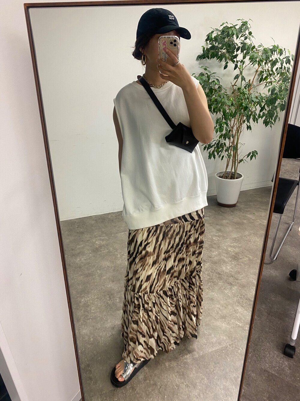 ブラック系のショルダーバッグ、ホワイト系のTシャツ/カットソー、ベージュ系のスカートを着用したレディースの夏コーディネートの5枚目の写真