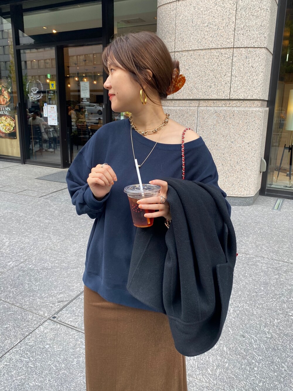 ブルー系のスウェット、ブラウン系のブーツ、レッド系のショルダーバッグを着用したレディースの秋コーディネートの6枚目の写真