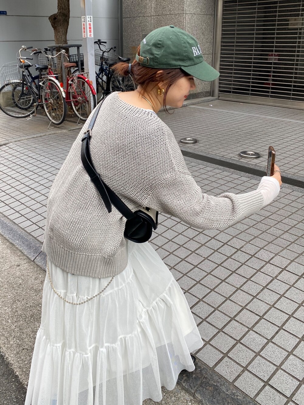 ホワイト系のニット/セーター、グレー系のテーラードジャケット、グリーン系のスカートを着用したレディースの春コーディネートの9枚目の写真