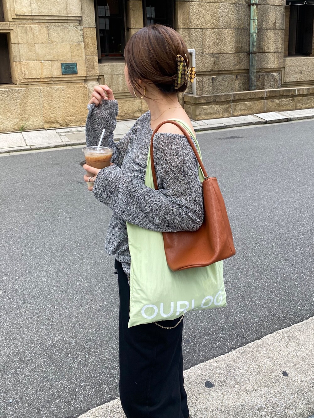 ブラック系のニット/セーター、ブルー系のスラックス、ブラウン系のショルダーバッグを着用したレディースの夏コーディネートの7枚目の写真
